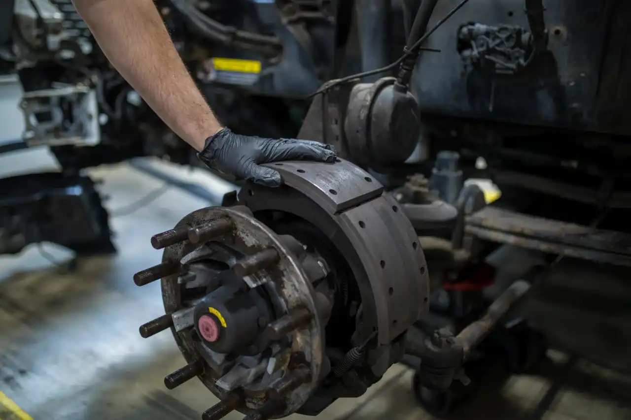 Technician checking brake disc on a commercial truck